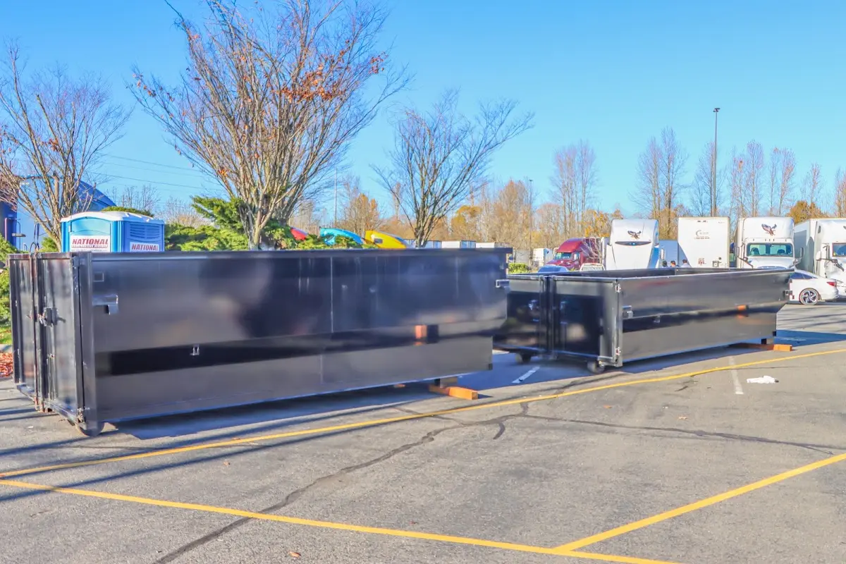 Professional dumpster rental service with roll-off container on residential driveway in Ayer